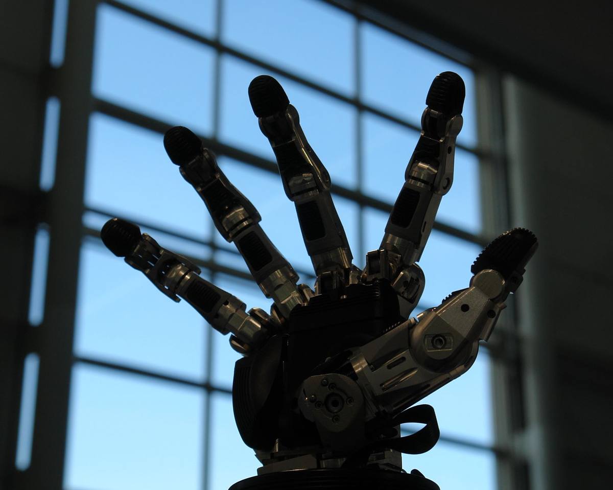 Pětiprstá robotická ruka Schunk SVH proti prosklené stěně