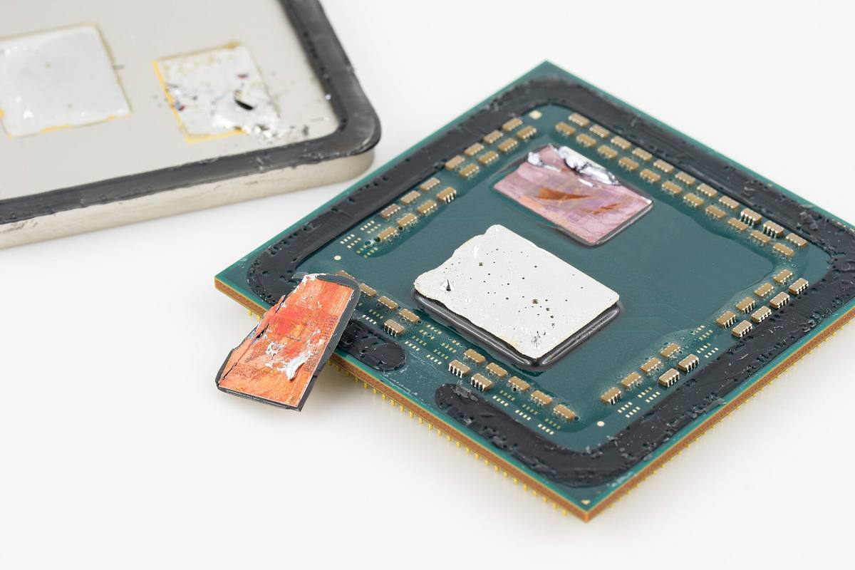 Procesor AMD Ryzen 5 5600X se sejmutým krytem, vidět jsou obě křemíkové destičky